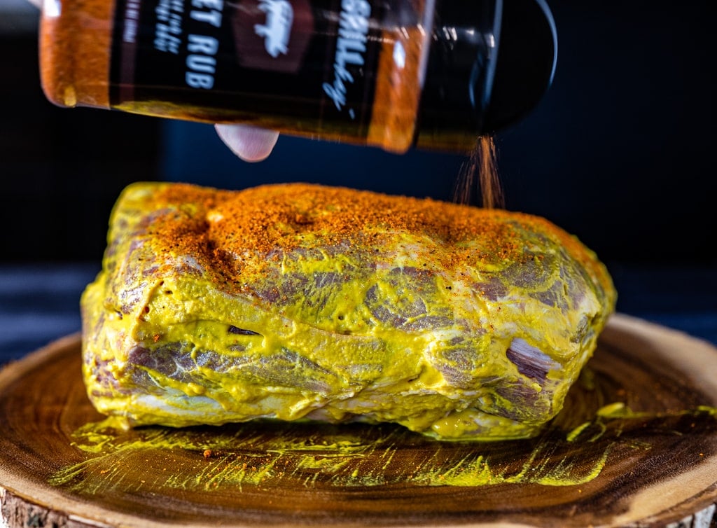 Mustard-slathered pork but being seasoned with Hey Grill Hey Sweet Rub.